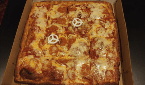 A square pizza topped with pepperoni and cheese, featuring two white peace sign decorations on top.