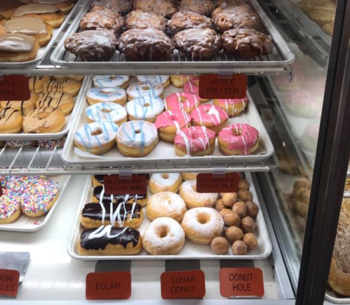 A display case filled with various donuts, including glazed, frosted, and filled varieties, all arranged neatly.