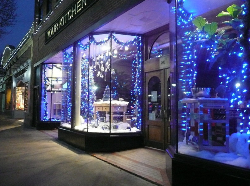 A storefront decorated with blue lights and winter-themed displays, creating a festive atmosphere.