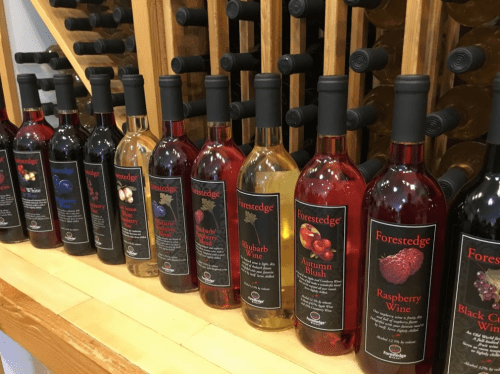 A display of various bottles of Forestedge wine, featuring different flavors like raspberry, rhubarb, and autumn blush.