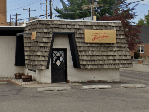 A small building with a distinctive sloped roof and a sign reading "Fredrickson's" in a parking lot.
