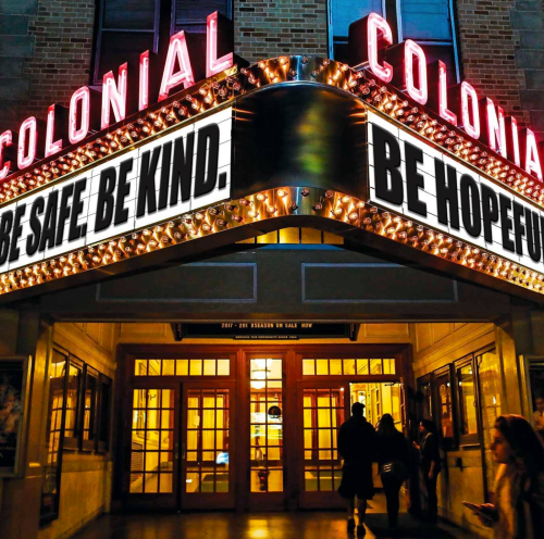 The Colonial Theatre marquee displays messages: "BE SAFE. BE KIND. BE HOPEFUL." with bright lights and an inviting entrance.