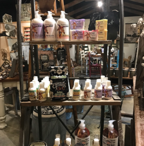 A wooden display shelf featuring various bottles of lotions and beauty products in a rustic store setting.