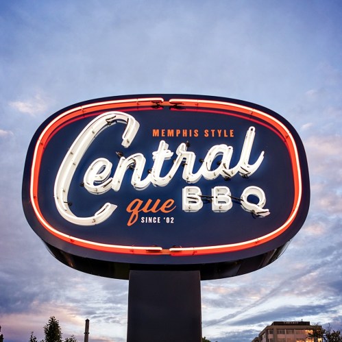 Neon sign for Central BBQ, featuring "Memphis Style" and "Since '02" against a twilight sky.