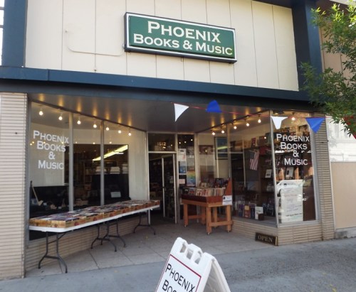 Exterior of Phoenix Books & Music, featuring a welcoming entrance and a display of books outside.