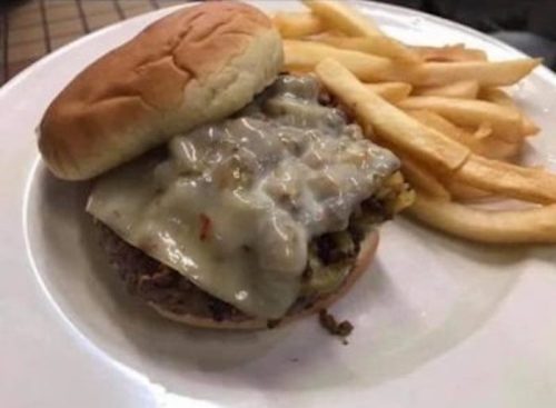 A plate featuring a cheeseburger with melted cheese and a side of golden French fries.