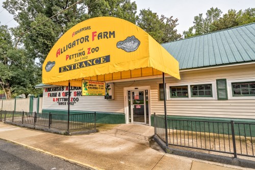Entrance of the Arkansas Alligator Farm and Petting Zoo, featuring a bright yellow awning and signage.