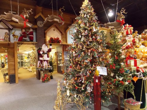 A festive indoor scene featuring a decorated Christmas tree, Santa figure, and holiday decorations throughout the store.