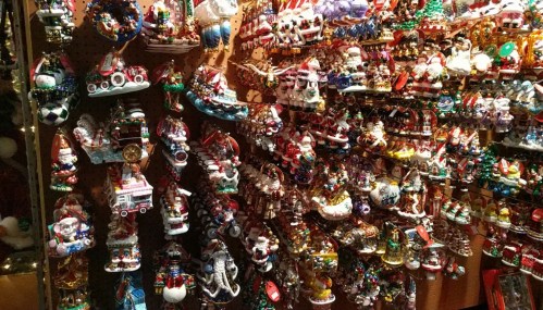 A colorful display of various Christmas ornaments, including Santa figures, snowmen, and festive decorations.