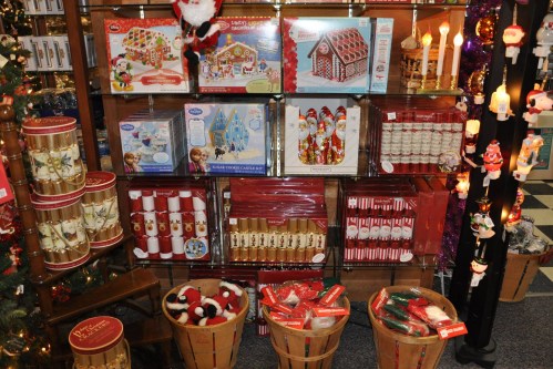 A festive display of holiday decorations, including gingerbread house kits, candles, and various ornaments.