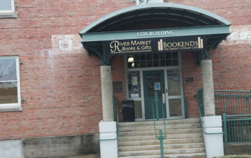 Entrance of the Cox Building featuring River Market Books & Gifts and Bookends, with brick facade and steps.