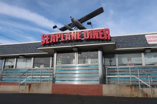 Exterior of Seaplane Diner featuring a seaplane on the roof and colorful striped windows.