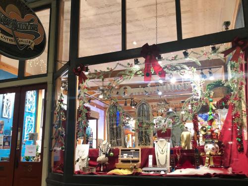 A festive jewelry store window display adorned with holiday decorations and elegant jewelry pieces.