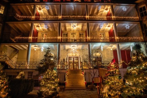 A beautifully decorated building with Christmas lights and trees, creating a festive holiday atmosphere.