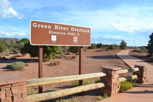 Sign for Green River Overlook at 6000 ft elevation, with a pathway and desert landscape in the background.