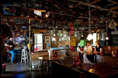 A cozy restaurant interior with wooden decor, a musician playing guitar, and diners enjoying their meals.