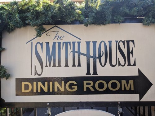 Sign for "The Smith House" with "Dining Room" arrow, decorated with greenery at the top.