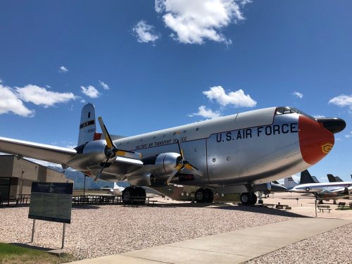 A vintage U.S. Air Force transport plane displayed outdoors under a clear blue sky.