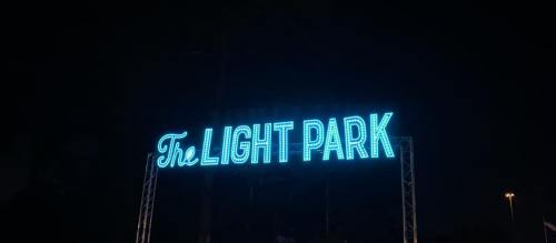 Neon sign reading "The Light Park" illuminated at night against a dark background.