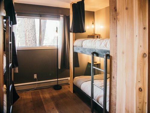 Cozy bedroom with bunk beds, wooden accents, and a large window letting in natural light.