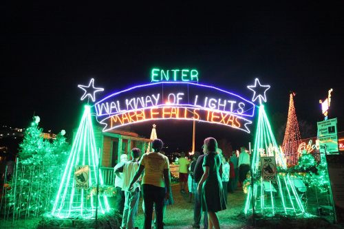 A colorful archway reading "Walkway of Lights" welcomes visitors to a festive display in Marble Falls, Texas.