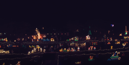 A vibrant display of colorful holiday lights and decorations illuminating a dark night sky.