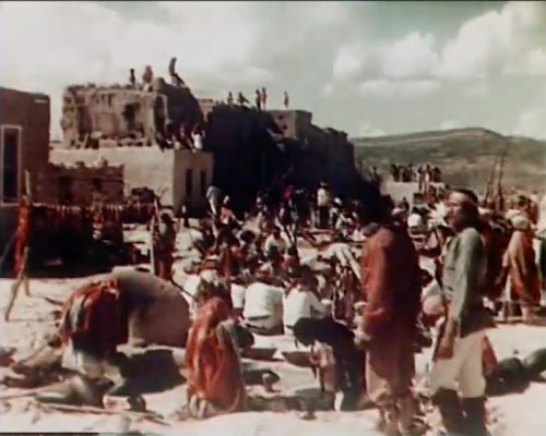 A historical scene depicting a large gathering of people around ruins, with some climbing on structures and others on the ground.