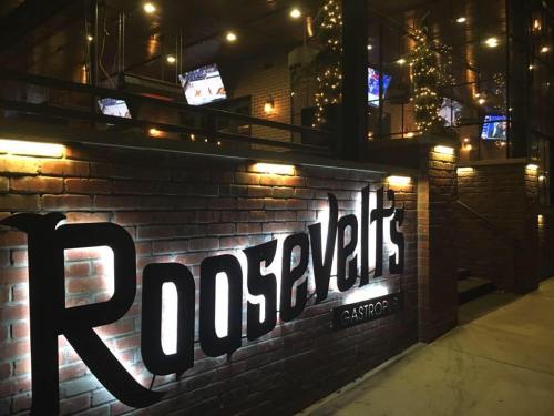 Exterior view of Roosevelt's Gastropub, featuring a brick facade and illuminated signage at night.