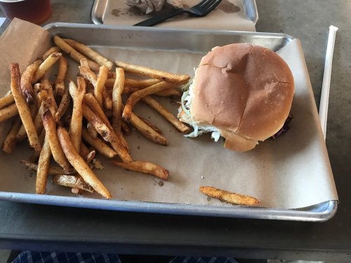 A tray with a sandwich and a generous serving of golden-brown fries on a paper liner.