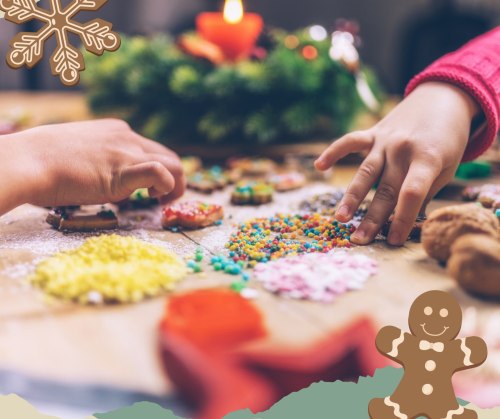 Two hands decorating festive cookies with colorful sprinkles and icing on a wooden table, surrounded by holiday decorations.