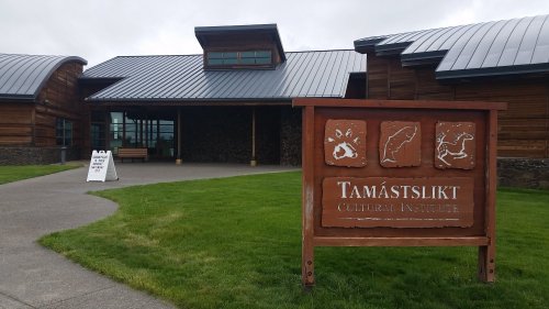 Exterior view of the Tamástslikt Cultural Institute, featuring a wooden building and a sign with cultural symbols.
