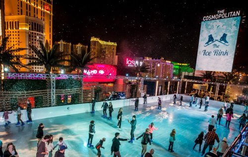 A vibrant ice rink at night, surrounded by palm trees and city lights, with people skating and enjoying the festive atmosphere.