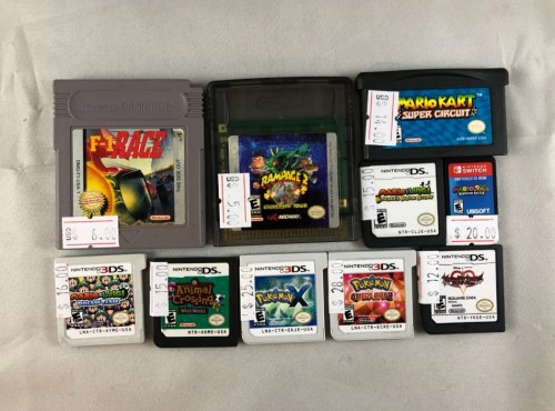A collection of video game cartridges for Game Boy and Nintendo DS, with price tags attached.