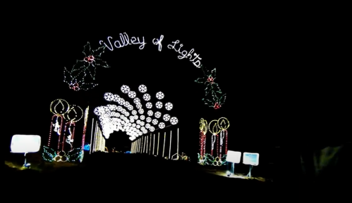 A festive archway reading "Valley of Lights" adorned with colorful holiday lights against a dark night sky.