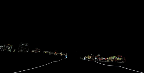 A dark scene with colorful holiday lights lining a road, creating a festive atmosphere.