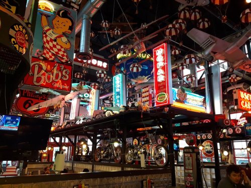 A vibrant diner interior filled with neon signs, vintage decor, and classic motorcycles, creating a nostalgic atmosphere.