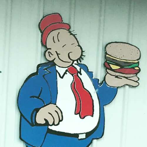 A cartoon character in a blue suit and red hat happily holds a hamburger, smiling against a white background.