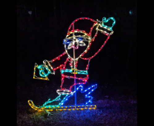 A colorful light display of Santa Claus skiing, waving with one hand, set against a dark background.