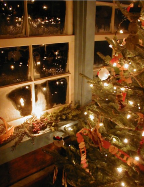 A cozy scene featuring a decorated Christmas tree beside a frosted window with glowing lights and candles.