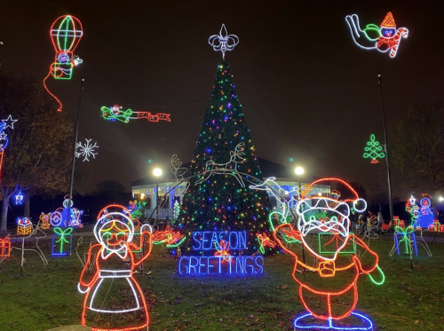 Colorful holiday lights display featuring a Christmas tree, Santa, and festive decorations with "Season Greetings" sign.