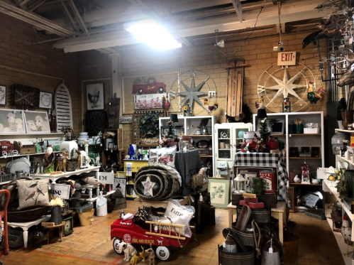 A cozy shop filled with vintage decor, furniture, and various home goods arranged on shelves and tables.
