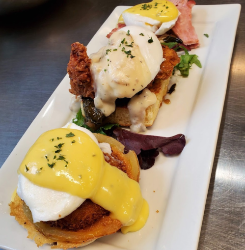 Three gourmet eggs Benedict on toasted bread, topped with poached eggs, hollandaise sauce, and garnished with herbs.