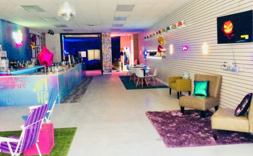 A colorful, modern interior of a cafe with vibrant decor, seating areas, and a bar counter.