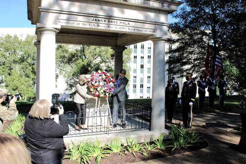 A ceremony at James Knox Polk's memorial, with officials placing a floral wreath and military personnel in attendance.