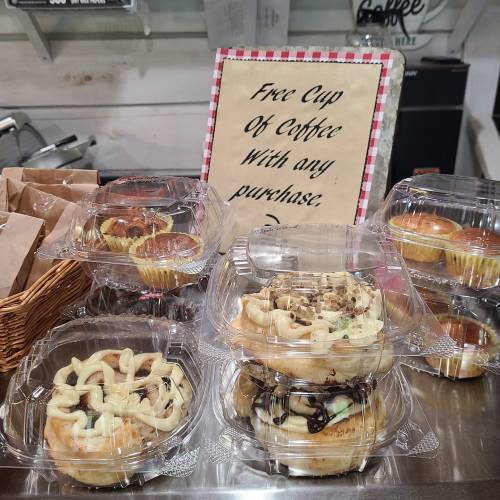 A display of assorted pastries and a sign offering a free cup of coffee with any purchase.