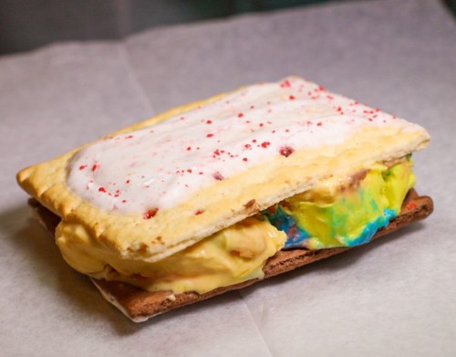 A colorful ice cream sandwich made with two Pop-Tarts and vibrant ice cream in between.