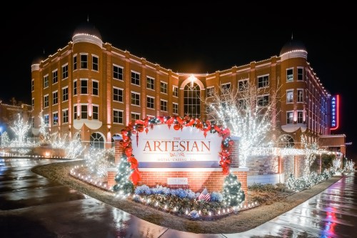 The Artesian Hotel and Casino, beautifully lit with festive holiday decorations at night.