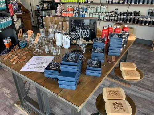 A display table with various gift items, including glasses, coasters, and decorative boxes, in a retail store.