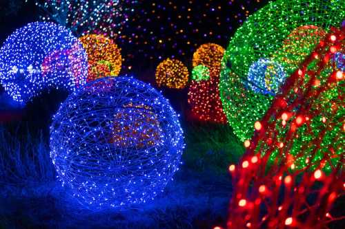 Colorful illuminated spheres made of lights in various sizes, creating a vibrant, festive atmosphere at night.