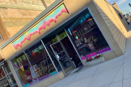 A colorful ice cream shop with a playful sign reading "Ice Cream Social" and vibrant decorations on the windows.